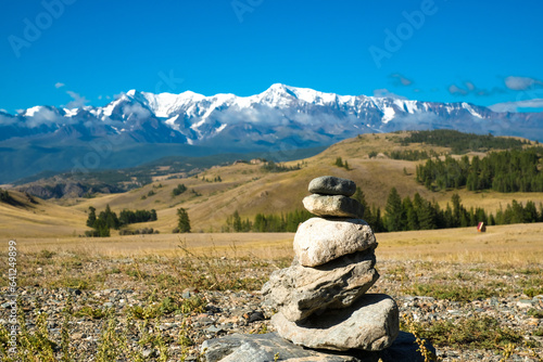 Rocky pyramides at mountain landscape with large snow peak mountains. Road trip to Altai. photo