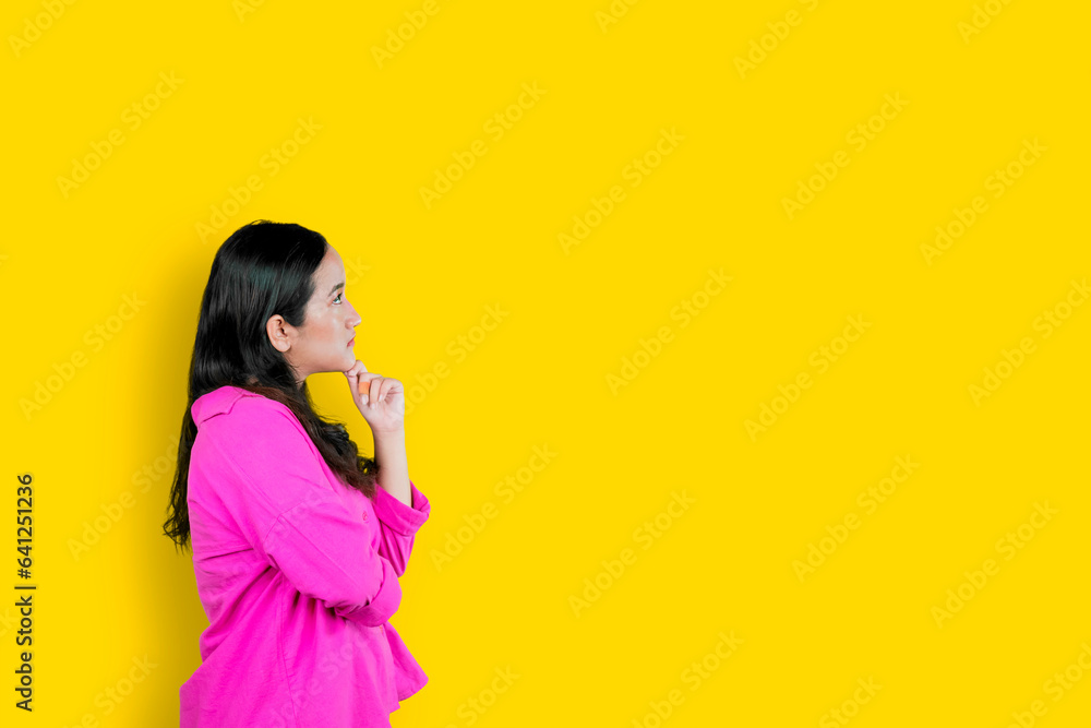 Thoughtful Asian woman keeps hand on chin looks pensively above Thoughtful Asian woman keeps hand on chin looks pensively above