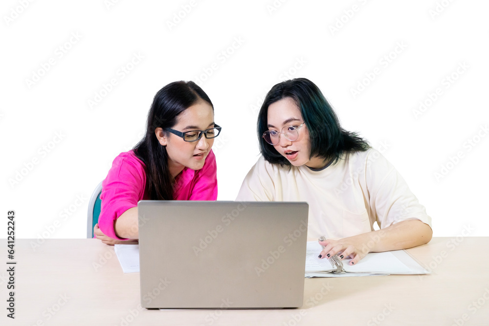 Two female students at the desk using working on laptop Two female students at the desk using working on laptop