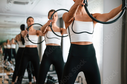 Three women in fitness center are doing exercises © standret