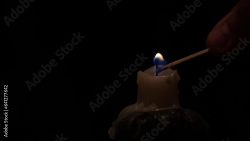 Lighting and burning candles in the dark, close-up