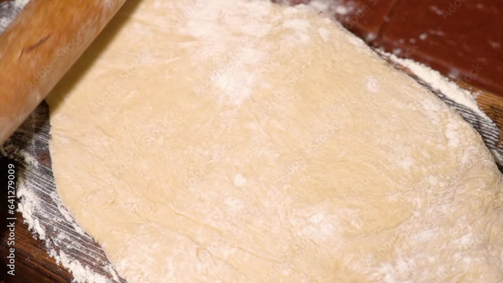 Process of homemade bake with wheat flour. The cook uses a rolling pin