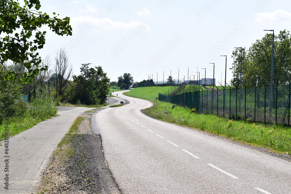 country road at the fence of a nuclear power plant