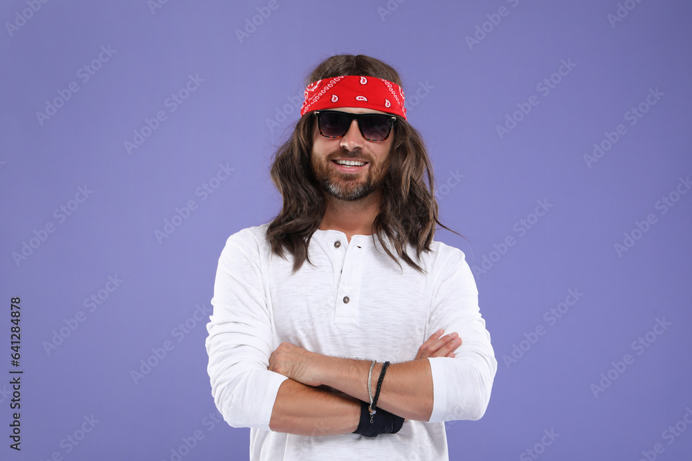 Stylish hippie man in sunglasses on violet background Stylish hippie man in sunglasses on violet background