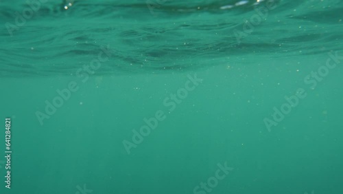 Camera above sea surface dives underwater, then resurfaces; drowning concept. photo