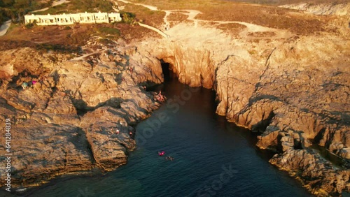 View from a drone at sunset on a bay with blue water. Cala Grotta, Sardinia island in Italy