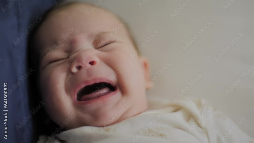 baby boy laying down on couch looking at camera baby boy laying down on couch looking at camera