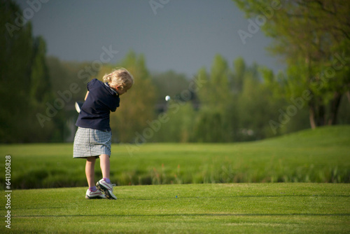 Golf drive with flyign ball  on golf course.