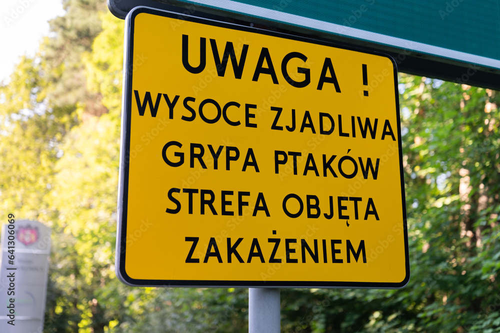 Warning sign in Poland. Avian influenza risk area, Polish information board. Uwaga! Wysoce zjadliwa grypa ptaków. Strefa objęta zakażeniem means Attention! Highly contagious bird flu. Infection zone.