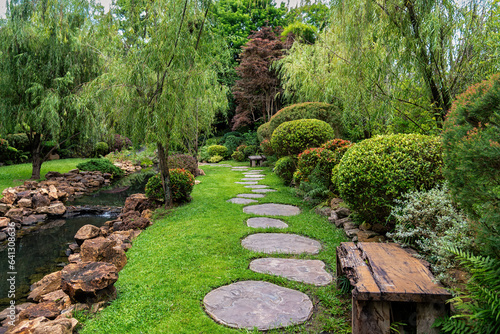 Canvas Print Stone stepping Walkway among lawn in a Japanese style garden.