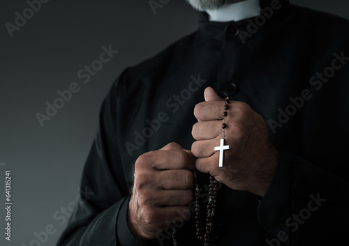 Fototapeta Close up of a priest holding rosary with copy space