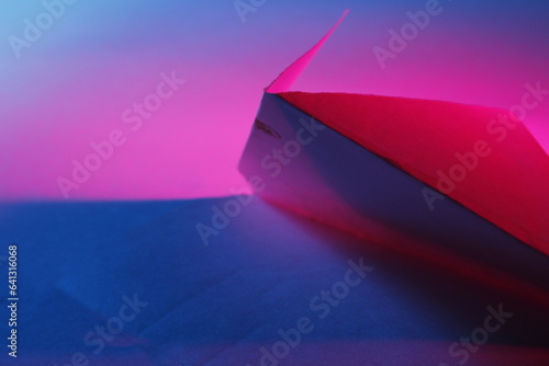 Tri  ngulos de cart  n para hacer cajas contenedoras con colores celeste  rosa y rojo  forman una original figura abstracta de l  neas rectas y espacio de dise  o para fondos.