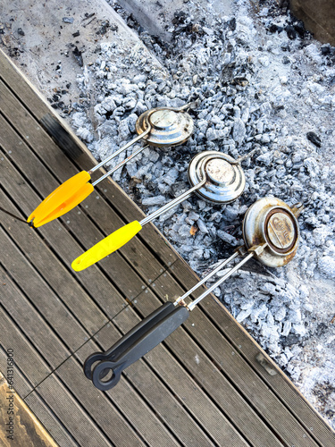 Three jaffle irons cooking on the coals photo