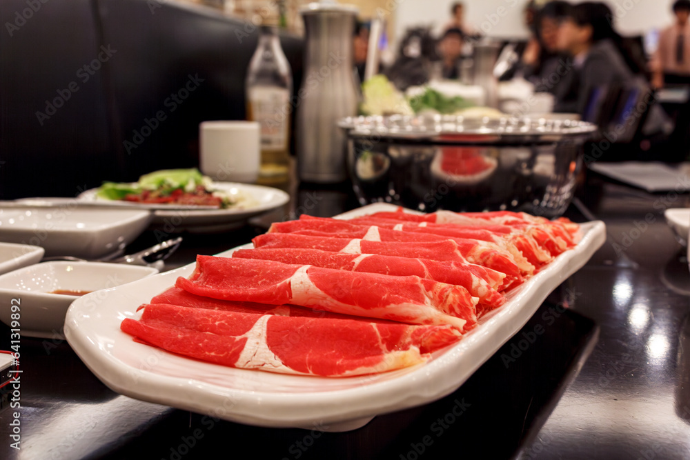 Plate of thin raw meat, rolled carpaccio