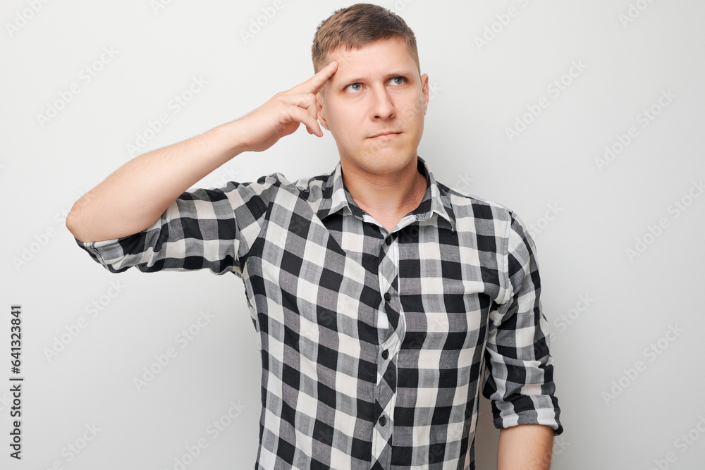 Portrait of clever man in shirt touching head thinks doubts chooses isolated on white studio background with copy space Portrait of clever man in shirt touching head thinks doubts chooses isolated on white studio background with copy space