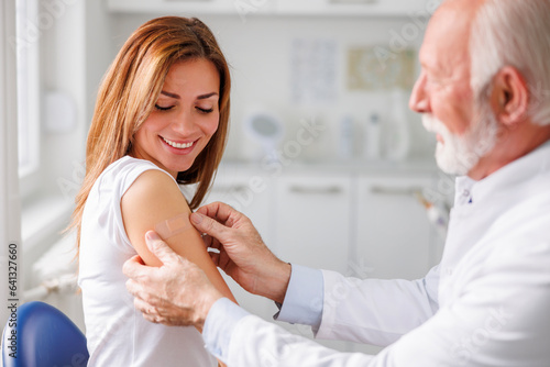 Obraz na plátne Healthcare specialist applying medical patch to patient after vaccination
