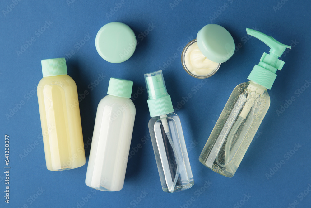 Travel cosmetic bottles on dark blue background. Minimalist bodycare beauty products for vacation or journey. Top view. Copyspace. Travel cosmetic bottles on dark blue background. Minimalist bodycare beauty products for vacation or journey. Top view. Copyspace.