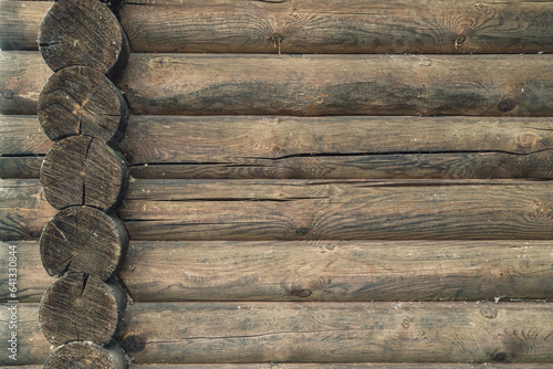 A log wall construction with a swedish cope log profile. Dirty and heavily cracked wall of a blockhouse as a background photo