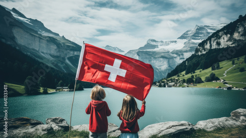 children holding the flag of Switzerland in the Alps. photo