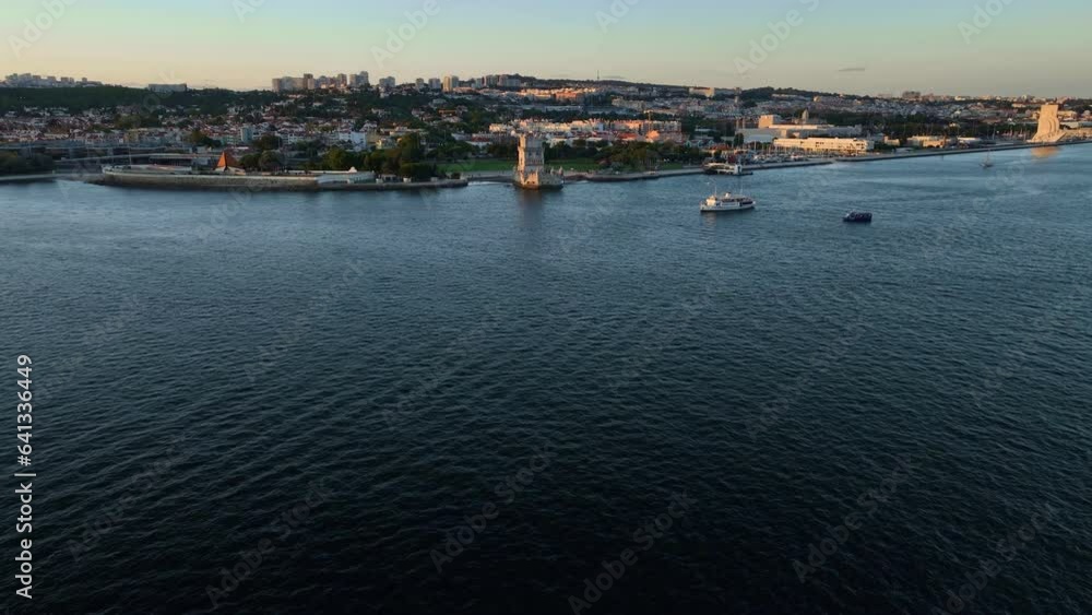 Aerial view of Belem Tower famous tourist landmark of Lisboa tourism attraction on bank of Tagus River (Tejo) with tourist yacht boats at sunset. Lisbon, Portugal. Push in fly over dolly drone shot Aerial view of Belem Tower famous tourist landmark of Lisboa tourism attraction on bank of Tagus River (Tejo) with tourist yacht boats at sunset. Lisbon, Portugal. Push in fly over dolly drone shot