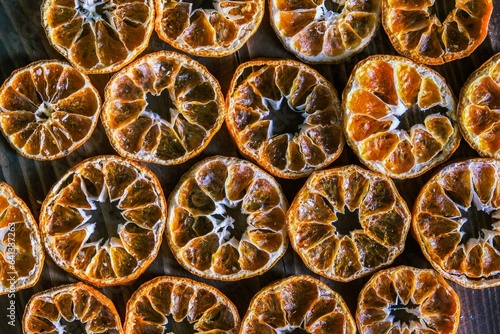 Dried orange slices on the wooden table. Dry citrus. Dried citrus fruits on the table. Orange slices top view. Tangerine or mandarin fruits