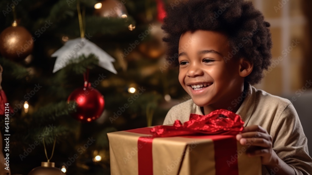 Adorable smiling African kid with a wrapped Christmas gift in a decorated living room. Close-up portrait of a happy boy with a Wrapped Christmas present at home with a Christmas tree in the background Adorable smiling African kid with a wrapped Christmas gift in a decorated living room. Close-up portrait of a happy boy with a Wrapped Christmas present at home with a Christmas tree in the background