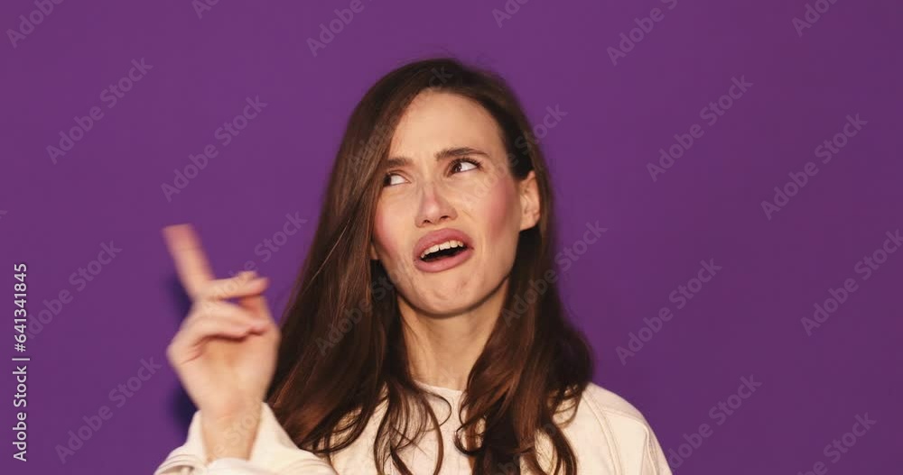 Young caucasian woman standing and thinking an idea pointing the finger up over isolated purple background. Girl have insight or good idea, look happy and smiling. Young caucasian woman standing and thinking an idea pointing the finger up over isolated purple background. Girl have insight or good idea, look happy and smiling.
