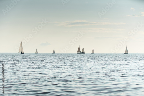 The sailing regatta, few boats on horizon line, sailing boats at sunset, still water, calm photo