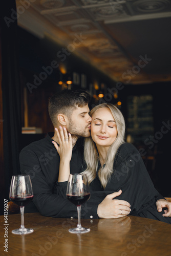 Couple hugging and have wine in cafe