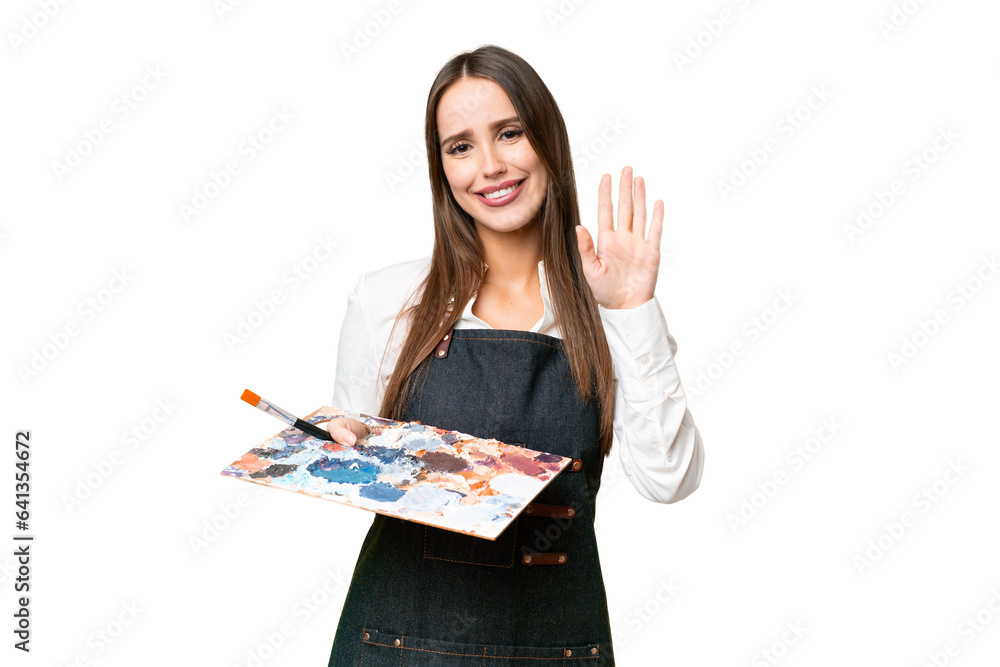 Young artist woman holding a palette over isolated chroma key background saluting with hand with happy expression Young artist woman holding a palette over isolated chroma key background saluting with hand with happy expression