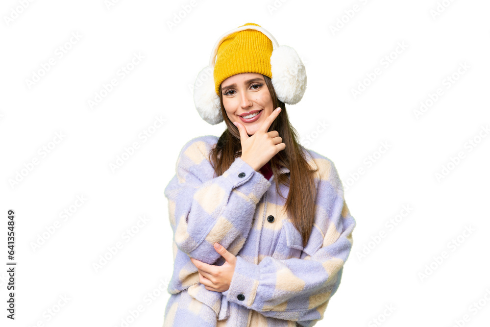 Young woman wearing winter muffs over isolated chroma key background smiling
