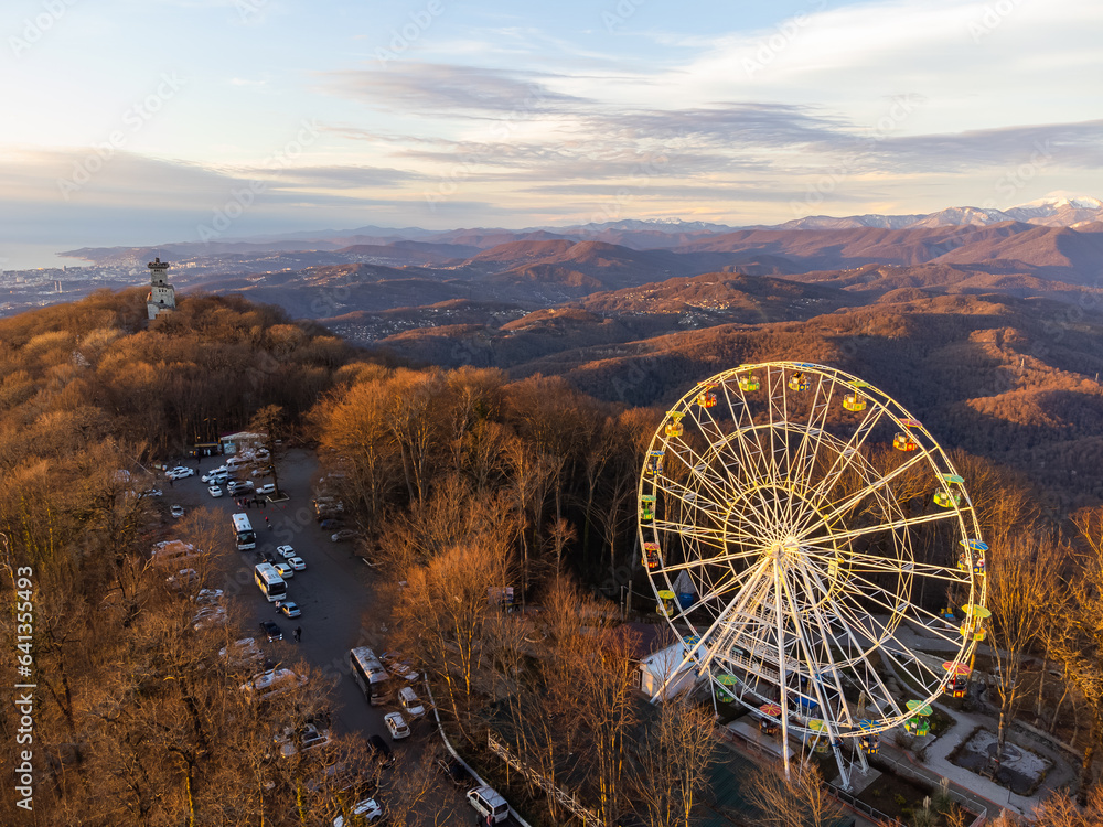 The Ferris wheel and observation tower with mountains in the background. High quality photo