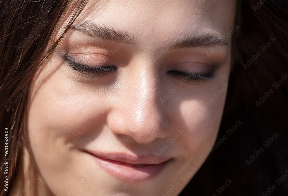 Close-up portrait of a beautiful young woman with eyes closed