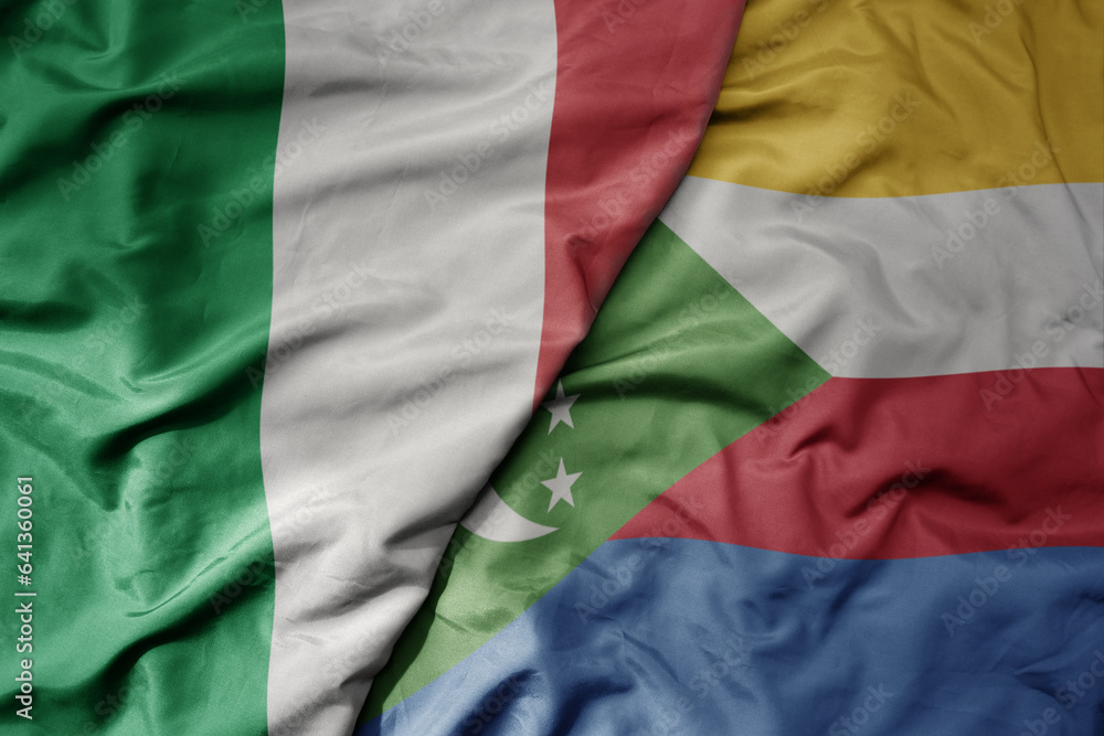 Obraz premium big waving national colorful flag of italy and national flag of comoros .