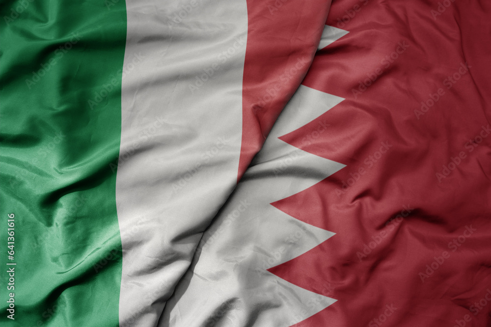 big waving national colorful flag of italy and national flag of bahrain .