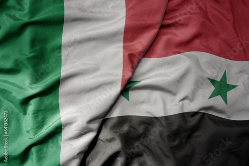 big waving national colorful flag of italy and national flag of syria .