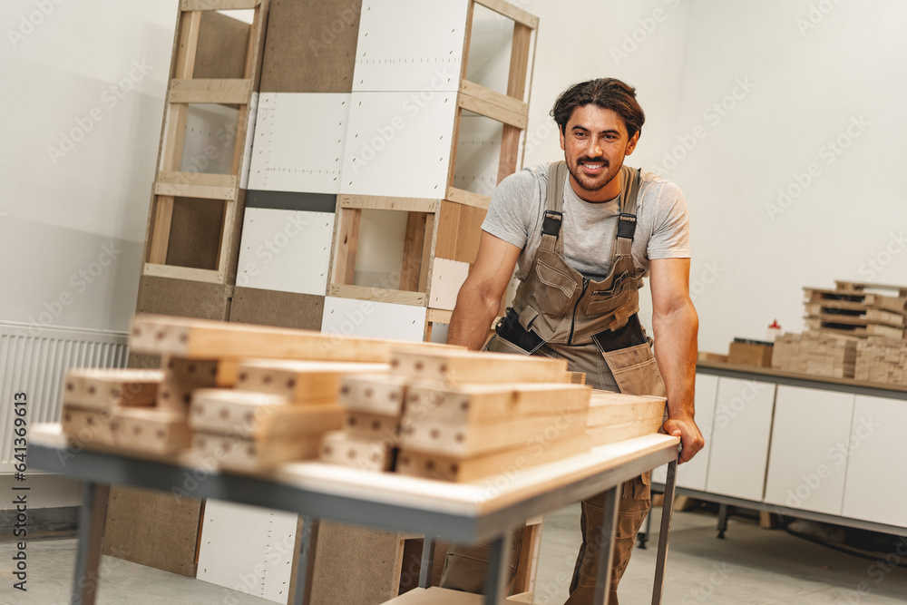 Portrait of young male carpenter standing in the wood workshop Portrait of young male carpenter standing in the wood workshop