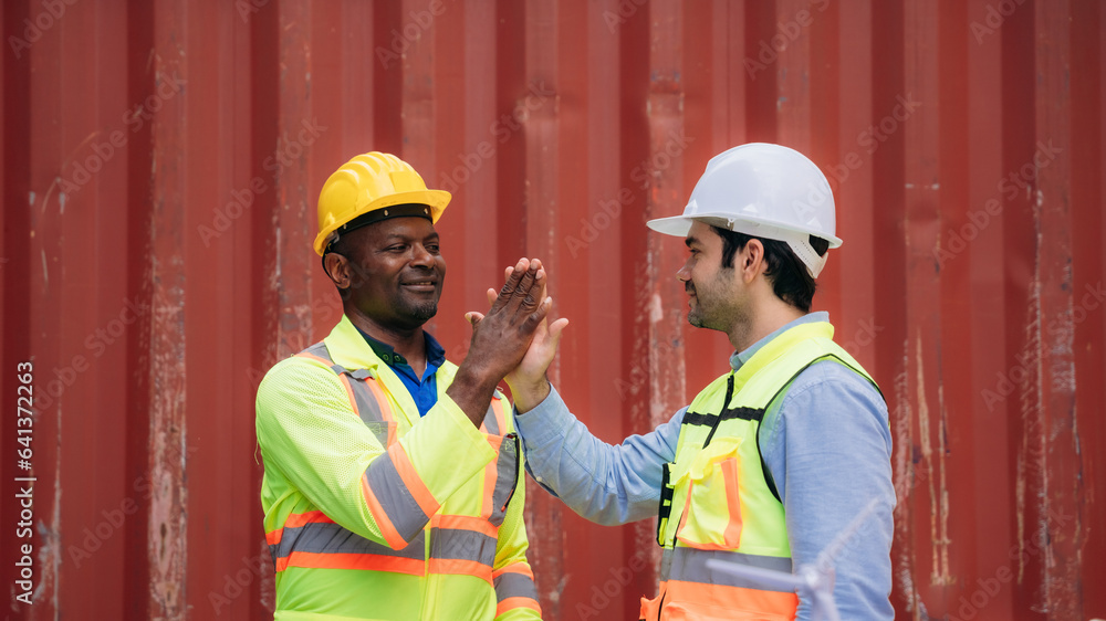 Team worker stack hand and shake hands to show success work at Container cargo harbor. Logistics concept inside the shipping, import, and export industries. Team worker stack hand and shake hands to show success work at Container cargo harbor. Logistics concept inside the shipping, import, and export industries.