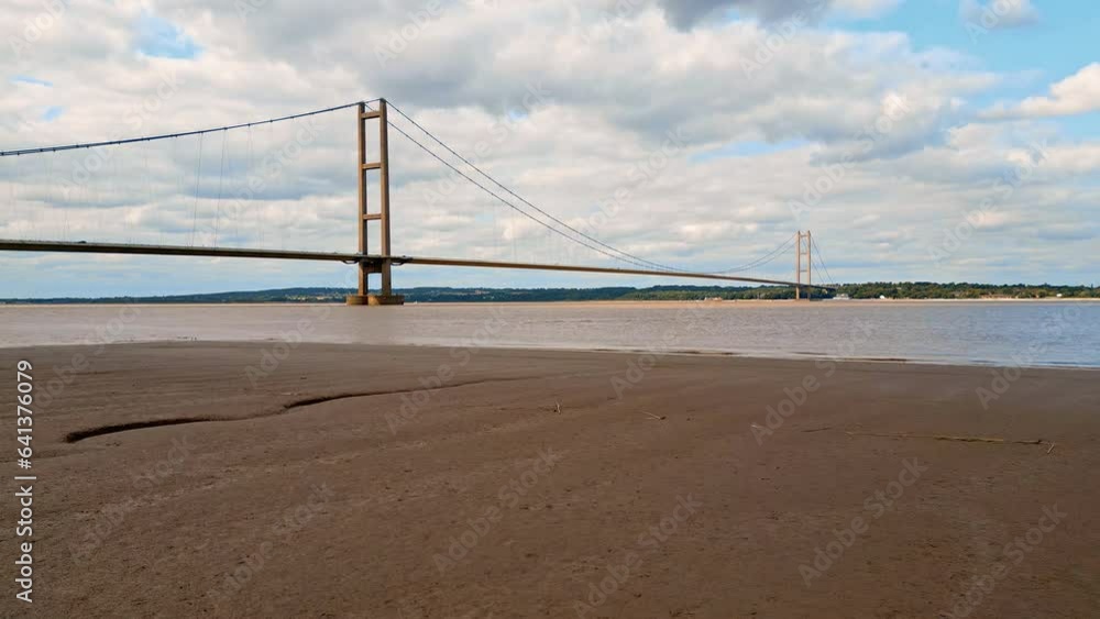 Aerial drone view of Humber Bridge, 12th largest suspension span, gracefully crossing River Humber, connecting Lincolnshire to Humberside with traffic. Aerial drone view of Humber Bridge, 12th largest suspension span, gracefully crossing River Humber, connecting Lincolnshire to Humberside with traffic.