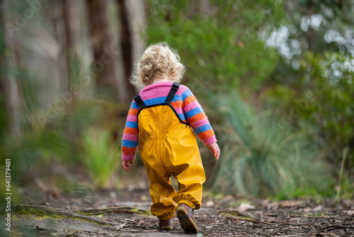 baby walking in a park in yellow overalls © Phoebe