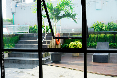 The view from the window opens to a courtyard with fresh green plants and is soothing to the eyes