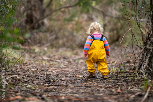 baby walking in a park in yellow overalls © William
