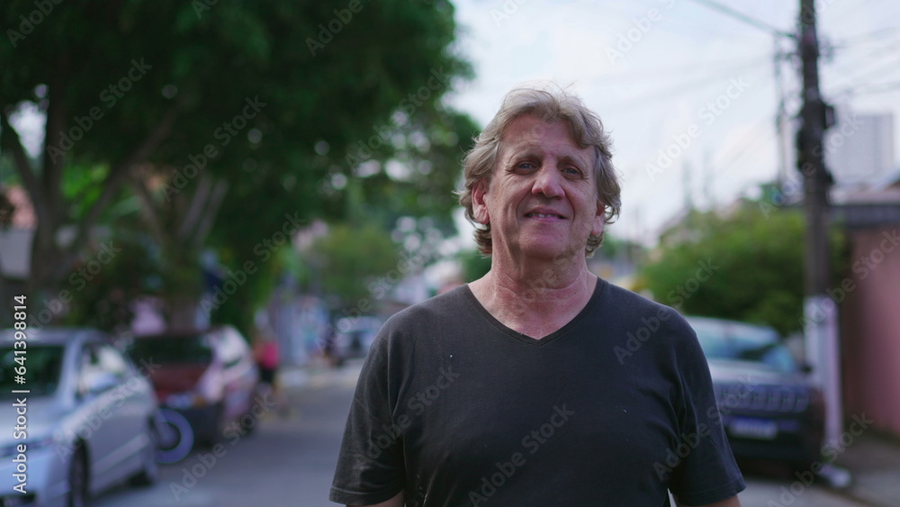 Joyful senior man walking in urban street, smiling in daily exercise stroll in urban setting. Portrait close-up face of an older caucasian person walks forward in tracking shot motion Joyful senior man walking in urban street, smiling in daily exercise stroll in urban setting. Portrait close-up face of an older caucasian person walks forward in tracking shot motion