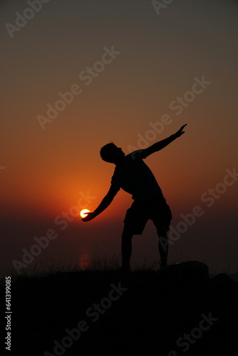 Silhouette of a person holding the sun