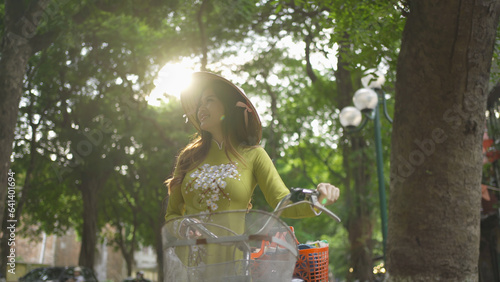 Portrait of Asian peddler with bike, Vietnamese woman girl traveling in Hanoi urban city town, Vietnam. People lifestyle.