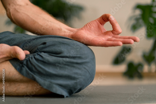 Photo close-up of hands and fingers of man meditating in hall and sitting in lotus pos