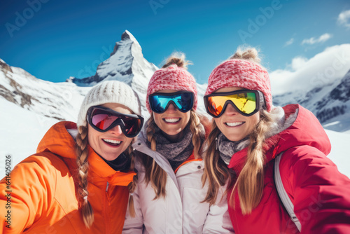 Three beautiful happy young women with sunglasses and winter clothing having fun in ski resort Matterhorn, winter holiday concept.