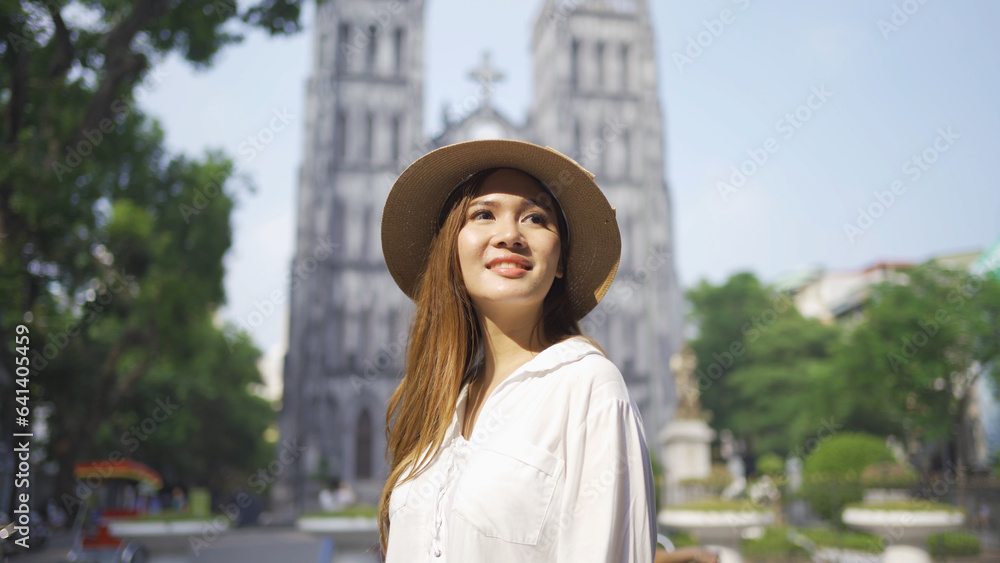 Portrait of Asian Vietnamese woman girl in St. Joseph's Cathedral church traveling in Hanoi urban city town, Vietnam. People lifestyle.