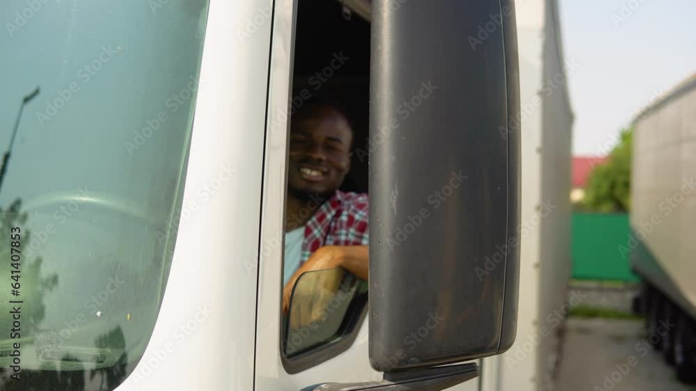 Black truck driver sitting in his truck. Trucker occupation. Transportation services Black truck driver sitting in his truck. Trucker occupation. Transportation services
