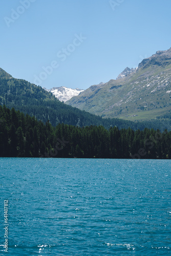 Mountain landscape and lake. View of beautiful mountain landscape in Alps with Silsersee lake, concept of an ideal resting place. Picturesque mountain lake in the summer morning.